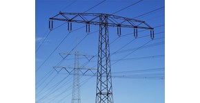 Zwei Hochspannungsmasten mit Freileitungen vor strahlend blauem Himmel Zwei Hochspannungsmasten mit Freileitungen vor strahlend blauem Himmel