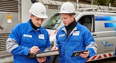 Zwei Techniker in Blaumännern betrachten Tablets vor einem Technikfahrzeug Zwei Techniker in Blaumännern betrachten Tablets vor einem Technikfahrzeug