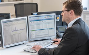 Mitarbeiter am Schreibtisch vor zwei Monitoren arbeitet am Rechner Mitarbeiter am Schreibtisch vor zwei Monitoren arbeitet am Rechner