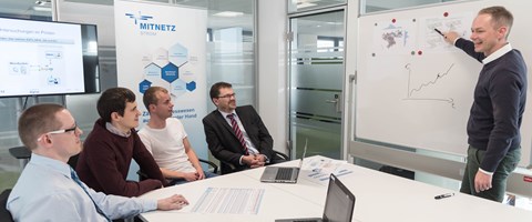 Mann hält Chart-Präsentation vor sitzender Gruppe Mann hält Chart-Präsentation vor sitzender Gruppe