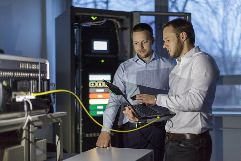 Zwei Mitarbeiter in weißen Hemden bei der Digitalisierung von Messsystemen