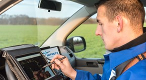 Ein Techniker arbeitet im Cockpit eines Fahrzeugs an einem portablen Eingabegerät Ein Techniker arbeitet im Cockpit eines Fahrzeugs an einem portablen Eingabegerät
