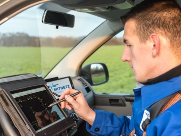 Ein Techniker arbeitet im Cockpit eines Fahrzeugs an einem portablen Eingabegerät Ein Techniker arbeitet im Cockpit eines Fahrzeugs an einem portablen Eingabegerät