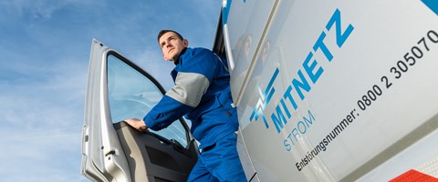 Ein Techniker steigt vor blauem Himmel aus einem Technikfahrzeug Ein Techniker steigt vor blauem Himmel aus einem Technikfahrzeug