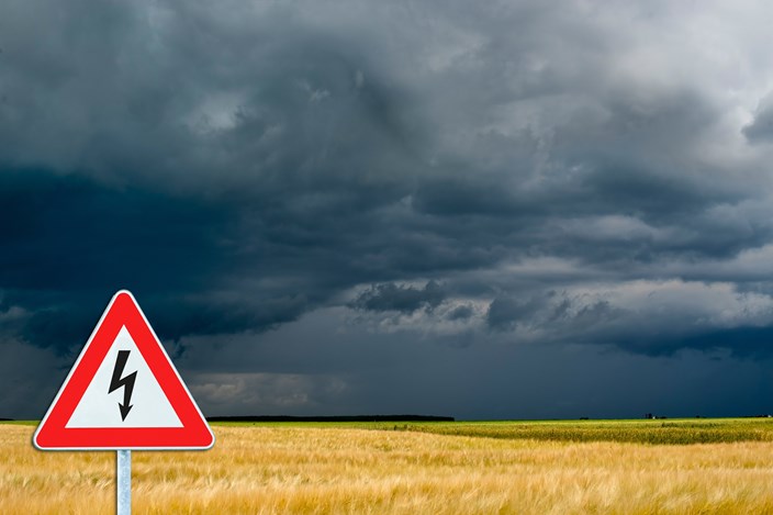 Hinweisschild Stromausfall 2 vor Wiese mit Sturmwolken Hinweisschild Stromausfall 2 vor Wiese mit Sturmwolken
