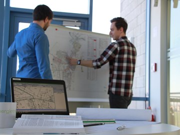 Zwei Personen stehen vor einer Pinnwand für eine Zielnetzplanung Zwei Personen stehen vor einer Pinnwand für eine Zielnetzplanung