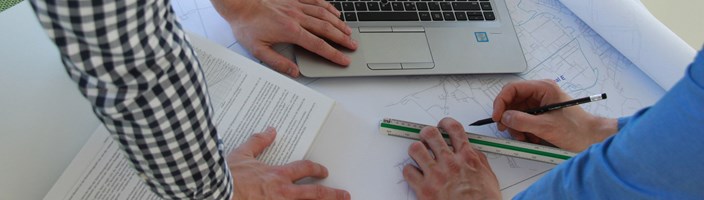 Mitarbeiter bearbeiten Netzplan und vergleichen Daten im Laptop Mitarbeiter bearbeiten Netzplan und vergleichen Daten im Laptop
