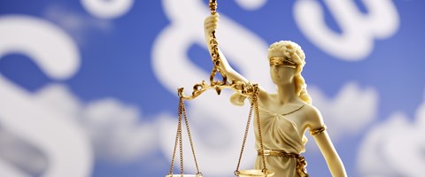 Justitia-Statue vor einem blauen Hintergrund mit weißen Paragrafenzeichen - Bildmontage Justitia-Statue vor einem blauen Hintergrund mit weißen Paragrafenzeichen - Bildmontage