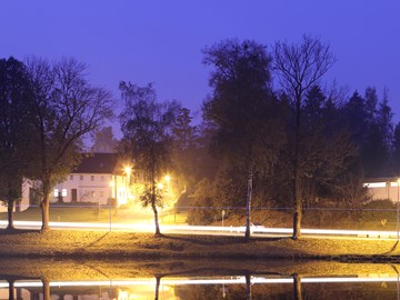 Lengenfeld - erleuchtete Straße vor einem Gewässer bei Nacht Lengenfeld - erleuchtete Straße vor einem Gewässer bei Nacht