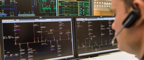 Mitarbeiter mit einem Headset vor mehreren Monitoren Mitarbeiter mit einem Headset vor mehreren Monitoren
