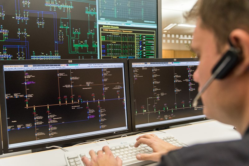 Mitarbeiter mit einem Headset vor mehreren Monitoren