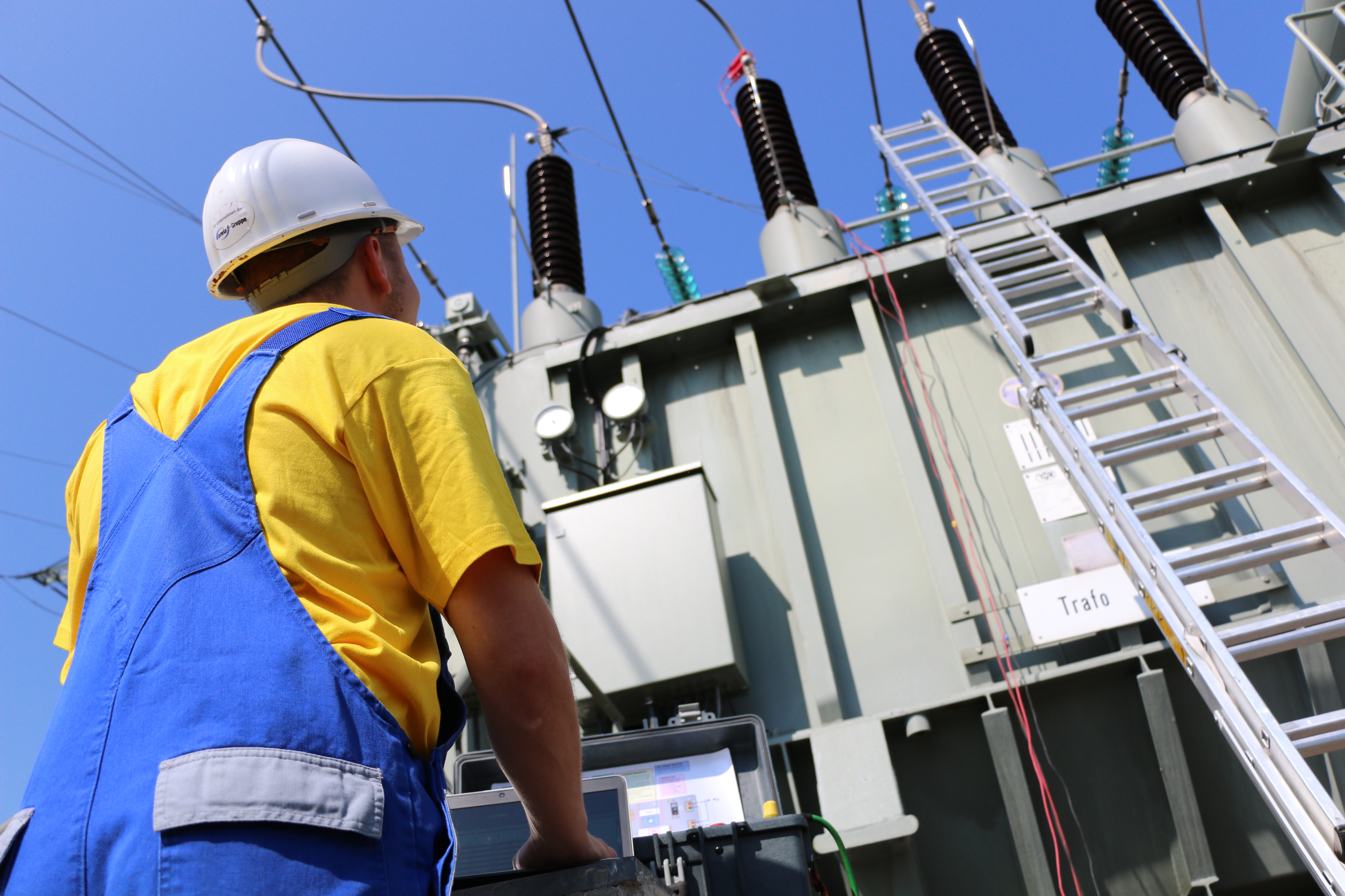 Mitarbeiter_steht_vor_den_Messgeräten_vor_dem_Transformator