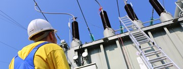 Mitarbeiter_steht_vor_den_Messgeräten_vor_dem_Transformator Mitarbeiter_steht_vor_den_Messgeräten_vor_dem_Transformator