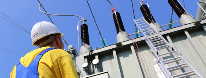 Mitarbeiter_steht_vor_den_Messgeräten_vor_dem_Transformator Mitarbeiter_steht_vor_den_Messgeräten_vor_dem_Transformator