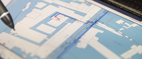 Spitze eines Stifts über einem Plan - Nahaufnahme Spitze eines Stifts über einem Plan - Nahaufnahme