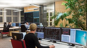 Drei Mitarbeiter sitzen im Büro der Schaltleitung vor Monitoren Drei Mitarbeiter sitzen im Büro der Schaltleitung vor Monitoren