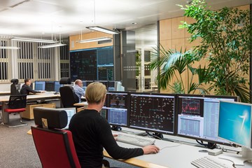 Drei Mitarbeiter sitzen im Büro der Schaltleitung vor Monitoren Drei Mitarbeiter sitzen im Büro der Schaltleitung vor Monitoren