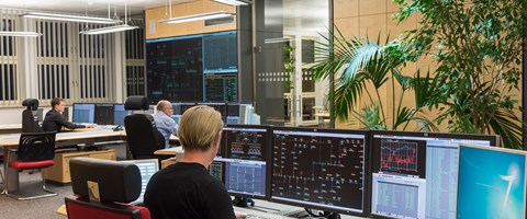 Drei Mitarbeiter sitzen im Büro der Schaltleitung vor Monitoren Drei Mitarbeiter sitzen im Büro der Schaltleitung vor Monitoren