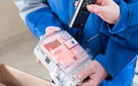 Hände mit Geräten bei der Ablesung eines Stromzählers Hände mit Geräten bei der Ablesung eines Stromzählers