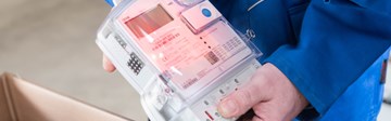 Hände mit Geräten bei der Ablesung eines Stromzählers Hände mit Geräten bei der Ablesung eines Stromzählers