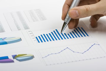 Hand mit Kugelschreiber über Diagrammen - Nahaufnahme Hand mit Kugelschreiber über Diagrammen - Nahaufnahme