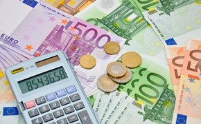 Taschenrechner und einige Münzen auf Eurobanknoten - Nahaufnahme Taschenrechner und einige Münzen auf Eurobanknoten - Nahaufnahme