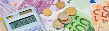 Taschenrechner und einige Münzen auf Eurobanknoten - Nahaufnahme Taschenrechner und einige Münzen auf Eurobanknoten - Nahaufnahme