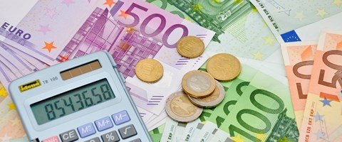 Taschenrechner und einige Münzen auf Eurobanknoten - Nahaufnahme Taschenrechner und einige Münzen auf Eurobanknoten - Nahaufnahme