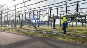 Mitarbeiter mit Helm und Warnschutzjacke bei Anlagen im Umspannwerk Mitarbeiter mit Helm und Warnschutzjacke bei Anlagen im Umspannwerk