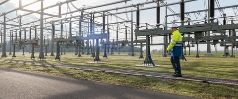 Mitarbeiter mit Helm und Warnschutzjacke bei Anlagen im Umspannwerk Mitarbeiter mit Helm und Warnschutzjacke bei Anlagen im Umspannwerk