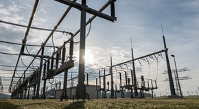 Anlage eines Umspannwerks vor einem sonnigen Himmel mit einigen Wolken Anlage eines Umspannwerks vor einem sonnigen Himmel mit einigen Wolken
