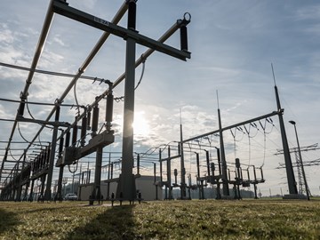 Anlage eines Umspannwerks vor einem sonnigen Himmel mit einigen Wolken Anlage eines Umspannwerks vor einem sonnigen Himmel mit einigen Wolken