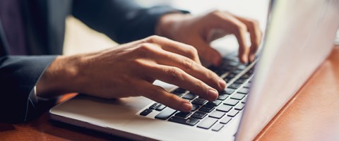 Nahaufnahme der Hände eines Geschäftsmannes auf einer Tastatur Nahaufnahme der Hände eines Geschäftsmannes auf einer Tastatur