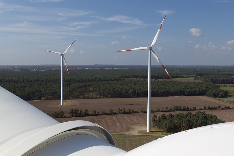 Sicht von dem Kopf eines Windrads auf ein Feld mit zwei weiteren Windrädern Sicht von dem Kopf eines Windrads auf ein Feld mit zwei weiteren Windrädern