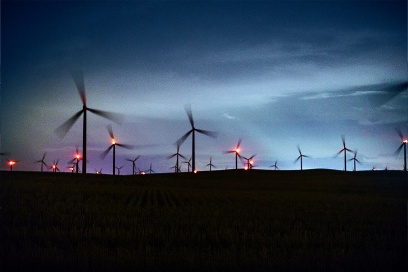 Bild eines Feldes mit Windrädern bei Nacht