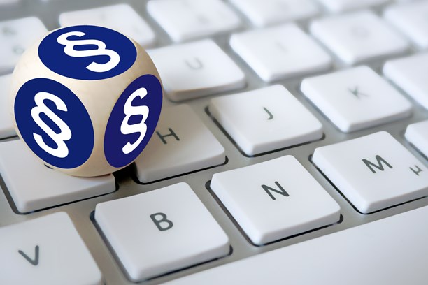 Ein Würfel, mit Paragrafenzeichen auf jeder Fläche, liegt auf einer Tastatur Ein Würfel, mit Paragrafenzeichen auf jeder Fläche, liegt auf einer Tastatur